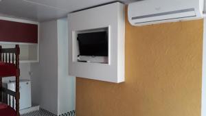 a room with a flat screen tv on a wall at Hospedaria Gaúcha in Penha
