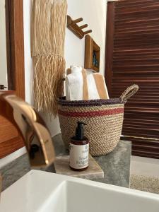 雅帕拉廷加的住宿－Kuarasy Boutique Hotel Japaratinga，一间带水槽的浴室和一个带毛巾的篮子