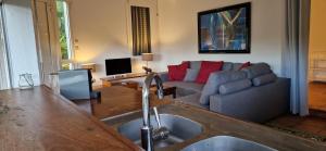 sala de estar con lavamanos y sofá en Habitation Villa Les Cassias, en Petit-Bourg