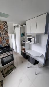 - une cuisine avec des placards blancs et une cuisinière dans l'établissement Av. Paulista Trianon MASP, à São Paulo