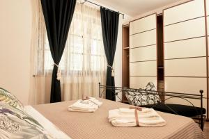 1 dormitorio con 2 toallas en una cama con ventana en Villa Belvedere - Località Barbiano, 3b, 50022 Greve in Chianti FI, Italy, en Greve in Chianti