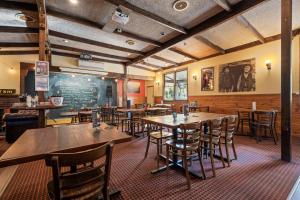 un restaurante con mesas y sillas de madera y una pizarra en The Harrietville Snowline Hotel, en Harrietville