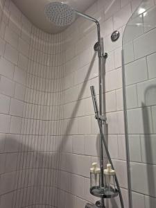 a shower in a bathroom with white tiles at Easy Host Porto in Porto