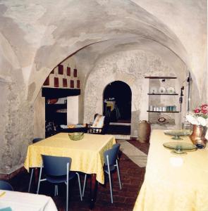 a room with two tables and chairs and a room with a stone wall at Il Borgo Agriturismo in Ferentillo