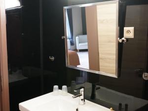 a bathroom with a sink and a mirror at Charming cottage with pool in Houffalize in Houffalize +32 photos