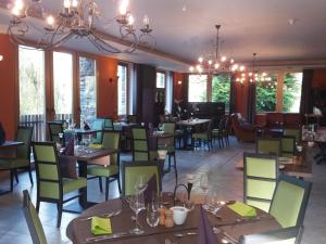 a restaurant with tables and chairs and a chandelier at Charming cottage with pool in Houffalize in Houffalize