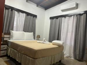 ein Schlafzimmer mit einem großen Bett mit Vorhängen in der Unterkunft SEVEN DAYS HOTEL B&B in San Pedro Sula