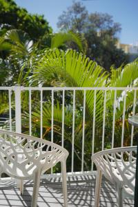 - 2 chaises blanches et une table sur la terrasse dans l'établissement Coolum Budget Accommodation, à Coolum Beach