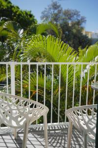 two white chairs and a table on a patio at Coolum Budget Accommodation in Coolum Beach