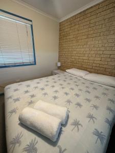 a bedroom with a bed with palm trees on it at Coolum Budget Accommodation in Coolum Beach