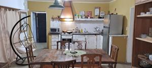 a kitchen with a wooden table with chairs and a refrigerator at MeliGchu in Gualeguaychú