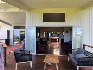 - un salon avec des chaises et une télévision murale dans l'établissement Avocado Retreat, à Rarotonga