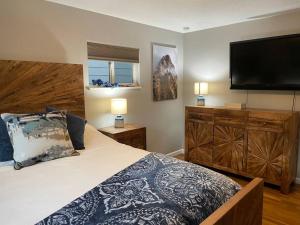 een slaapkamer met een groot bed en een flatscreen-tv bij Spacious 4 bdr w/ Game Room 5 min Drive to College in Boulder