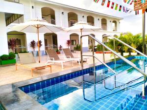a pool at a hotel with chairs and umbrellas at Hori hotel in Ban Nong Khaman