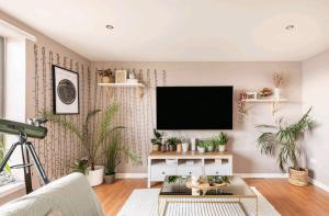 a living room with potted plants and a flat screen tv at King size room in well decorated flat in Edinburgh