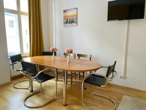 a dining room table with chairs and a television at 100 m2 Apartment - Free Parking- 15 min to Center in Vienna