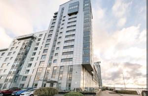 a tall white building with cars parked in front of it at King size room in well decorated flat in Edinburgh