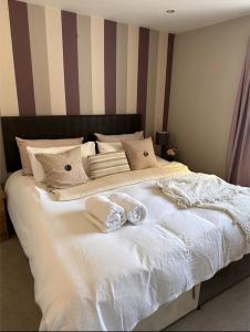 a large white bed with two towels on it at King size room in well decorated flat in Edinburgh