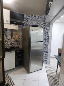 a kitchen with a stainless steel refrigerator in a room at Apartamento Rio Centro in Rio de Janeiro