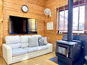 un soggiorno con divano e piano cottura di Foresta Karuizawa 1 a Oiwake