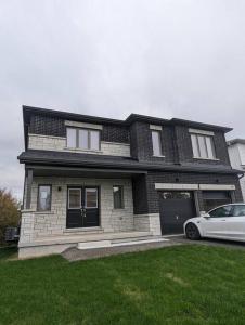 a house with a car parked in front of it at Stylish 5-Bedroom Retreat Near Port Dover and Turkey Point Beach in Simcoe