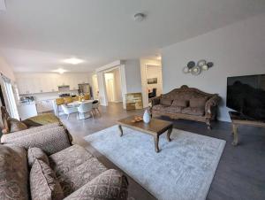 a living room with two couches and a table at Stylish 5-Bedroom Retreat Near Port Dover and Turkey Point Beach in Simcoe