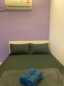 - un lit avec 2 oreillers bleus au-dessus dans l'établissement Bahtek Home with pool & private parking, à Ampang