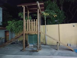 a playground with a wooden slide in front of a fence at Loca da Lagosta in Barra Grande