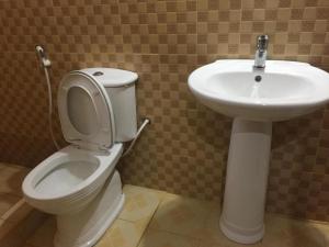 a bathroom with a toilet and a sink at Mafia Neptune Villa Lodge in Utende