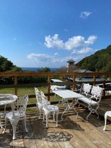 a table and chairs on a deck with a view of the ocean at Shirahama Meiji Villa in Shirahama