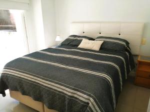 1 dormitorio con 1 cama grande con manta blanca y negra en Green Park Punta del Este, en Punta del Este