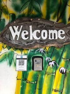 a sign with the word welcome on a wall at Basari Guest House in Lundu