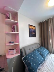 a bedroom with a bed and a pink shelf at HM Cozy Place beside Enchanted Kingdom in Santa Rosa