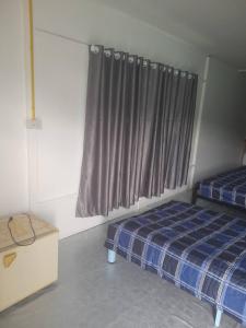 a bedroom with two twin beds and a window at บ้านสวนปวิชญา เกษตรอินทรี in Fang +84 photos