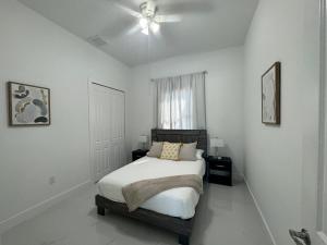 a white bedroom with a bed and a ceiling fan at Dream Family Home Vacation in Cape Coral +34 photos