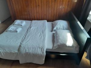 1 cama con 2 sábanas blancas y almohadas en Marci Room SweetHome, en Marcinelle