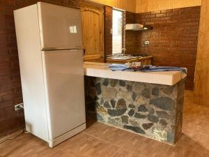 uma cozinha com um frigorífico e uma bancada em Cabañas Altura de Varillar em Varillar