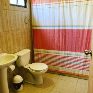 uma casa de banho com um WC e uma cortina de chuveiro em Cabañas Altura de Varillar em Varillar