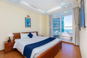 a bedroom with a bed and a large window at Amazing Seaview - Thuy Tien Building in Vung Tau