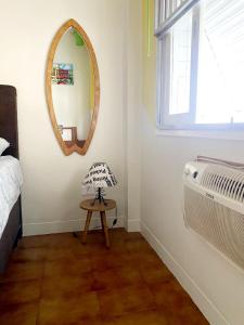 um quarto com um espelho, uma mesa e uma cama em Apartamento Messi Assú Praia dos Milionários em São Vicente