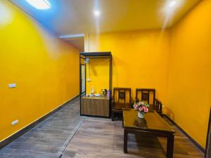 a bathroom with a yellow wall with a table and a sink at Old Quarter Hanoi Autumn House in Hanoi