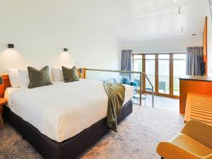 a bedroom with a large bed and a balcony at Strahan Village in Strahan