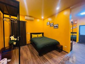 una camera con un letto e una parete gialla di Old Quarter Hanoi Autumn House a Hanoi