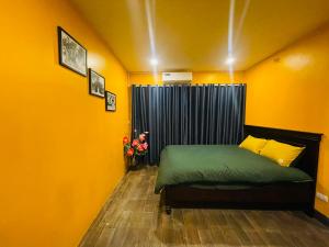 una camera da letto con pareti gialle e un letto verde di Old Quarter Hanoi Autumn House a Hanoi