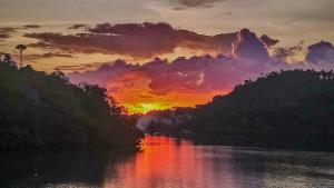 una puesta de sol sobre un río con la puesta de sol en Edgewater Dive & Spa Resort, en Puerto Galera