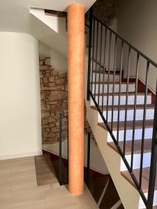 a spiral staircase with a brick wall and a column at Piccolo Borgo in Negrar