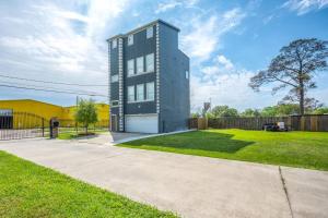 a modern house with a lawn and a fence at Gorgeous Home w/ Amazing View of Houston Skyline in Houston
