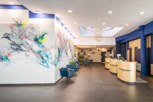 a lobby with chairs and paintings on the wall at Renaissance Paris Arc de Triomphe Hotel in Paris