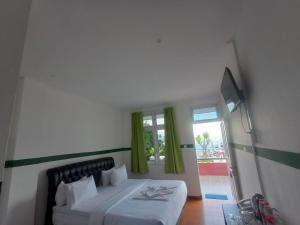 Ένα ή περισσότερα κρεβάτια σε δωμάτιο στο Hotel Ompu Herti