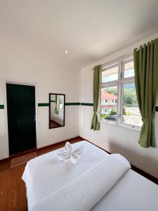 una camera da letto con un letto bianco con un arco sopra di Hotel Ompu Herti a Balige